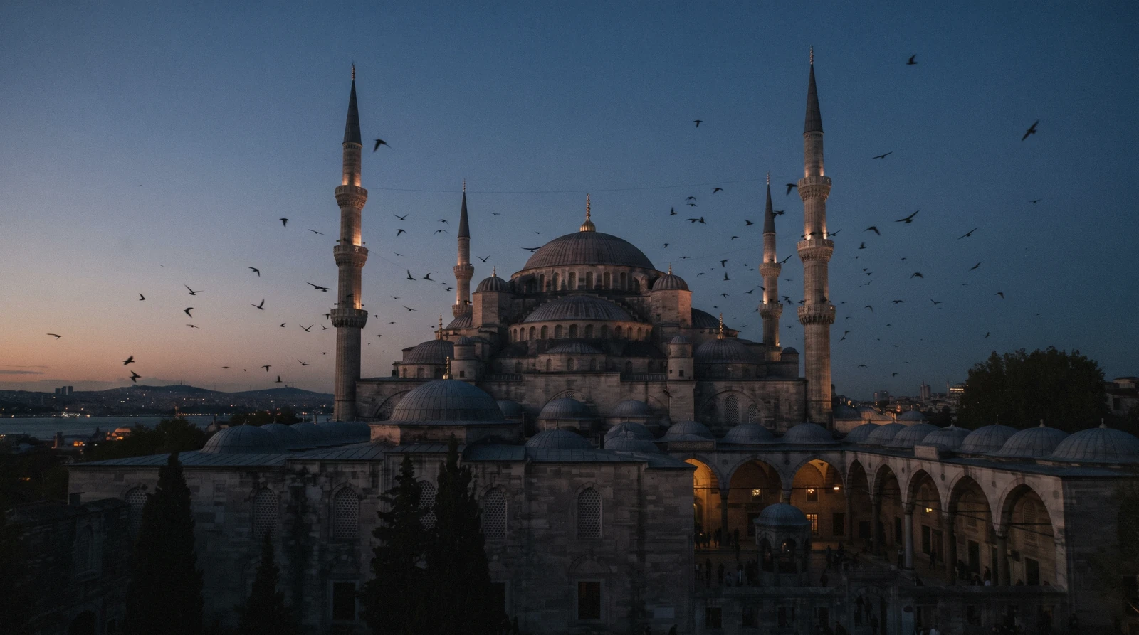 Domes and minarets of an imperial mosque against the evening sky in Istanbul, Türkiye